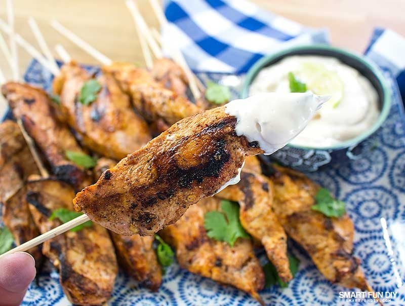 cooked chicken skewers on latter with dip