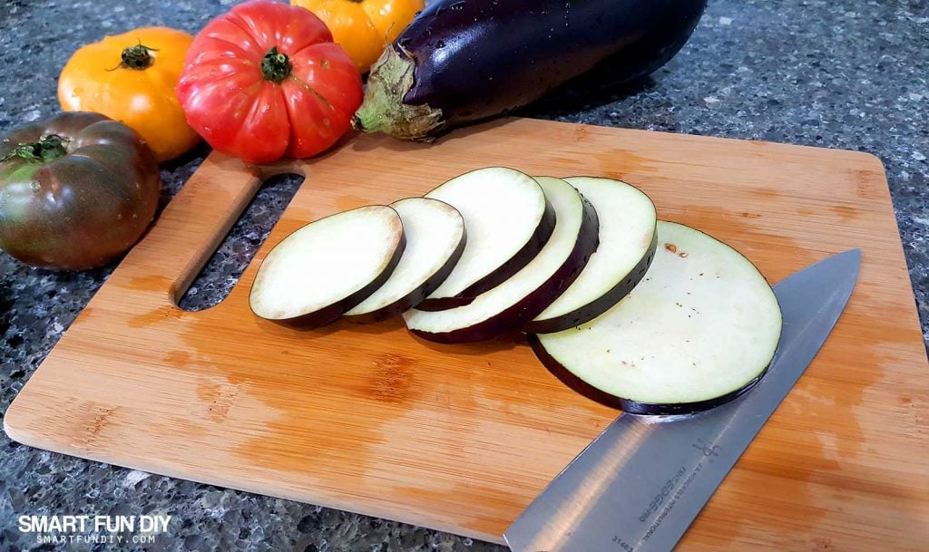 Slice eggplant to make a grilled eggplant and heirloom tomato salad recipe https://www.smartfundiy.com/mothers-day-lunch-grilled-eggplant/ #SoWorthIt