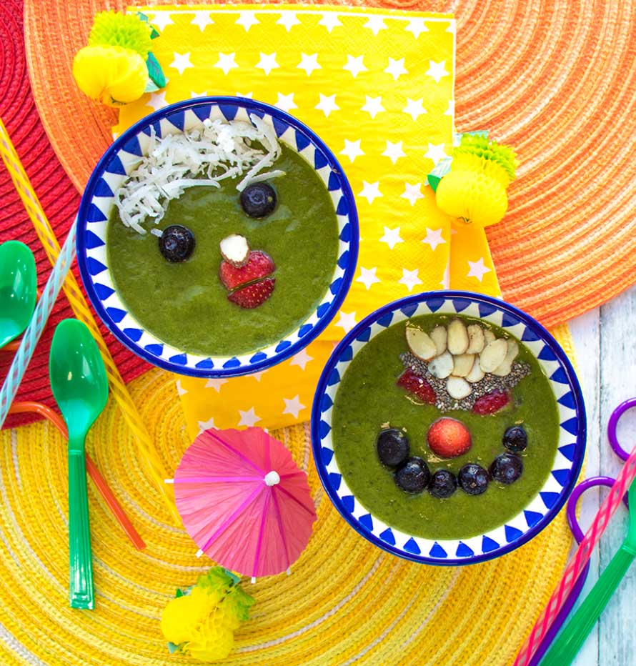 Kids Smoothie Bowls with funny faces made from fruit, nuts, and shredded coconut