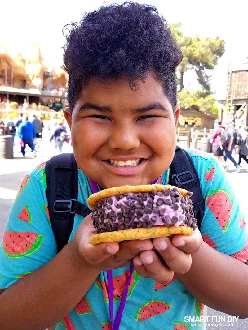 Boy with boysenberry ice cream cookie sandwich