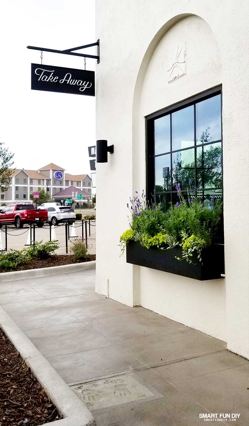 Flower Box and window at Magnolia Table restaurant with Chip and Joanna Gaines handprints in concrete