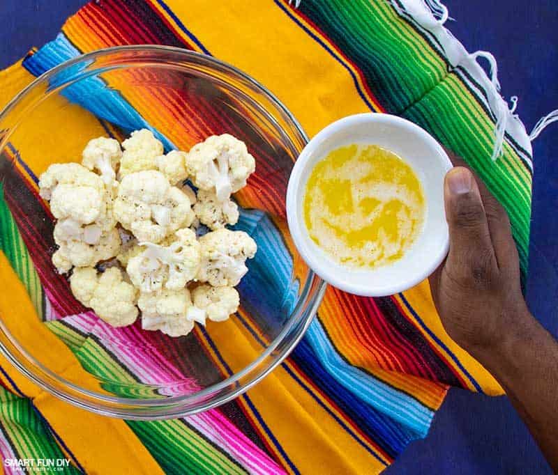 Adding butter to cauliflower florets for spicy cauliflower recipe Adding butter to cauliflower florets for spicy cauliflower recipe