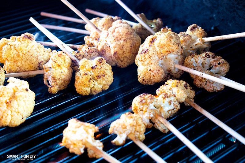 Grilling cauliflower lollipops Cauliflower lollipops on hot grill with smoke rising
