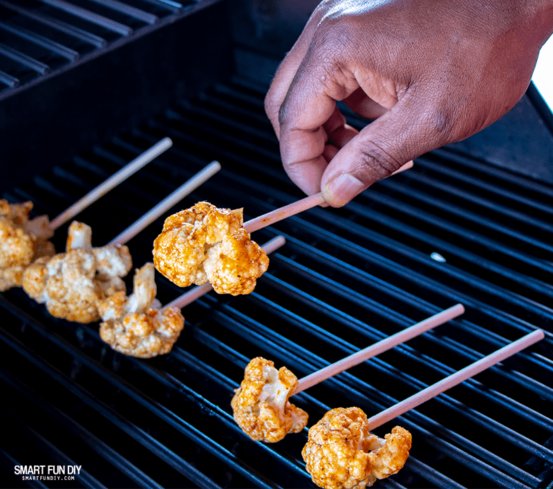 Place cauliflower florets on hot grill Placing cauliflower florets on hot grill for spicy cauliflower recipe