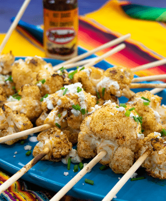 Spicy Cauliflower Lollipops on platter in fron ot El Yucateco hot sauce chile chipotle