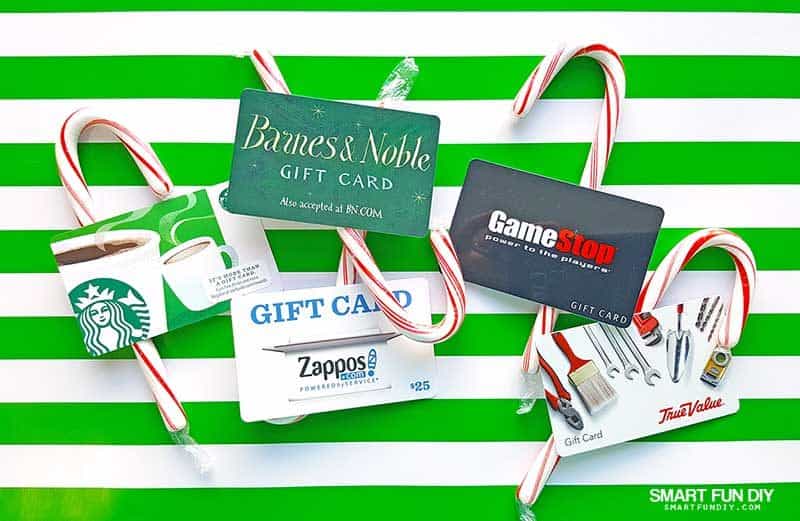 gift cards and candy canes on green striped wrapping paper