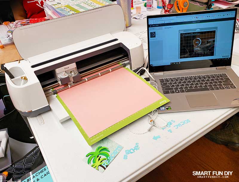 Cricut Maker and laptop on scrapbooking table at scrapbook crop