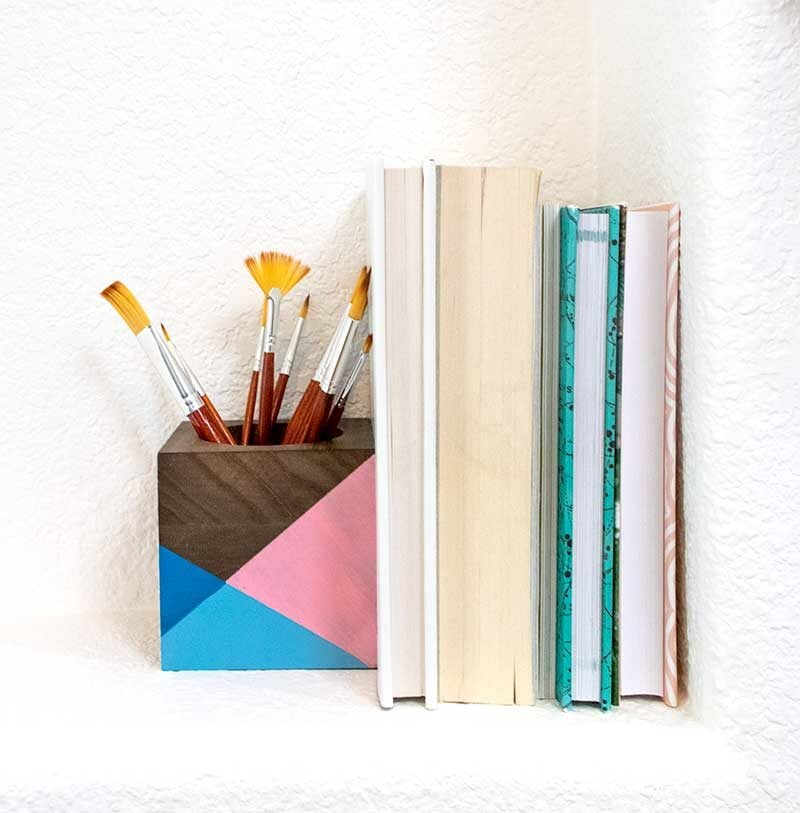 painted modern wood block book end holding up books