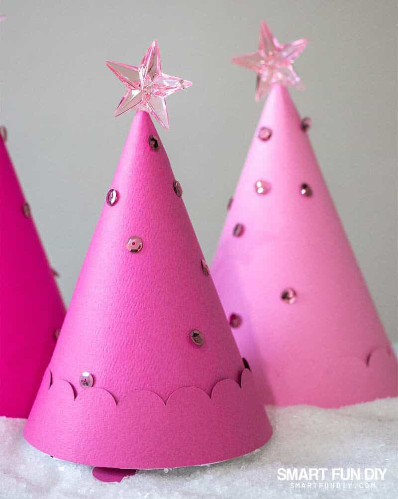 Pink paper cone Christmas trees decorated with sequins with gifts hidden inside