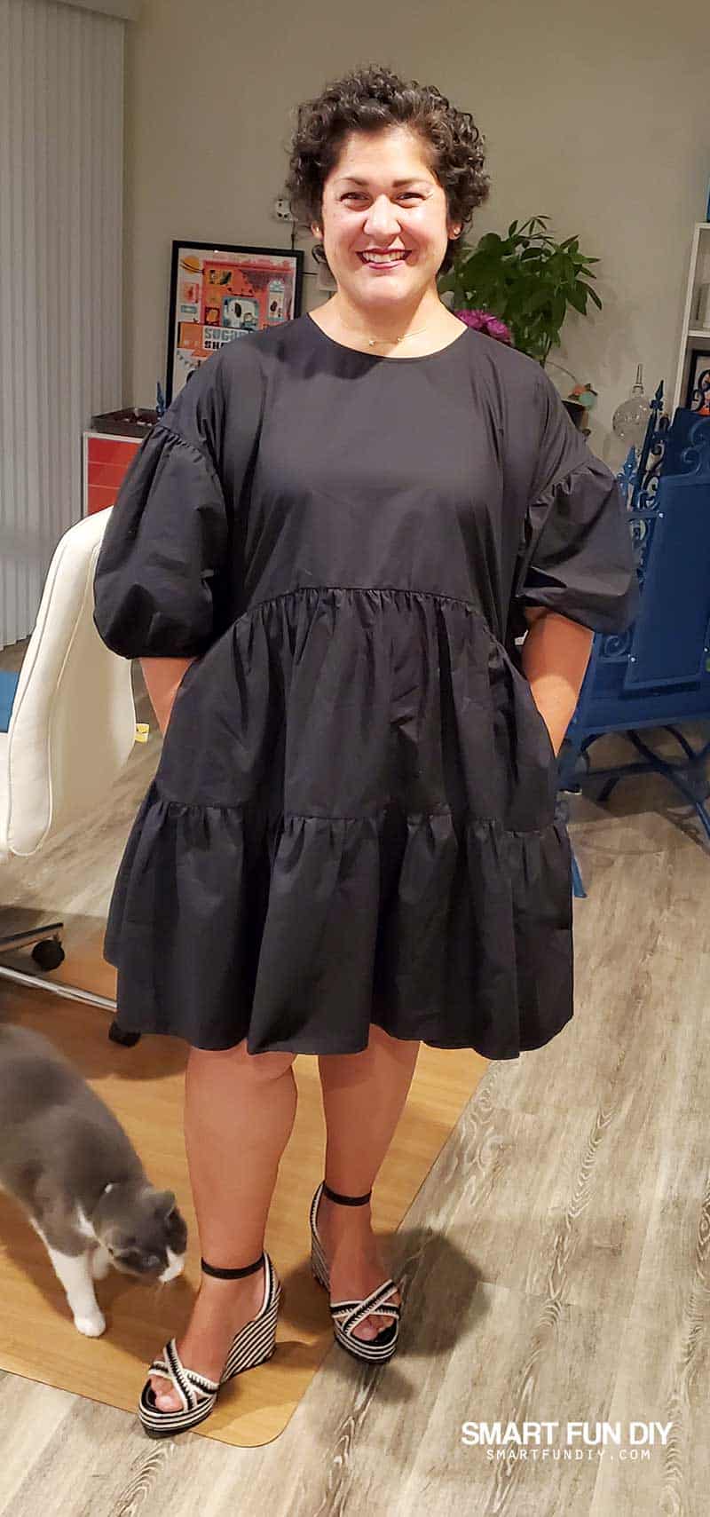 Jennifer Priest September 2020 in black puffy babydoll dress with black and white striped wedge sandals