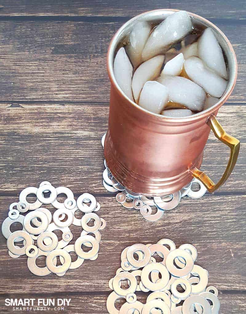 mug of soda with ice on top of plain metal washer coasters