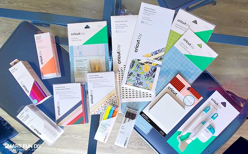 Accessories and materials for Cricut Joy machine laid on a glass table